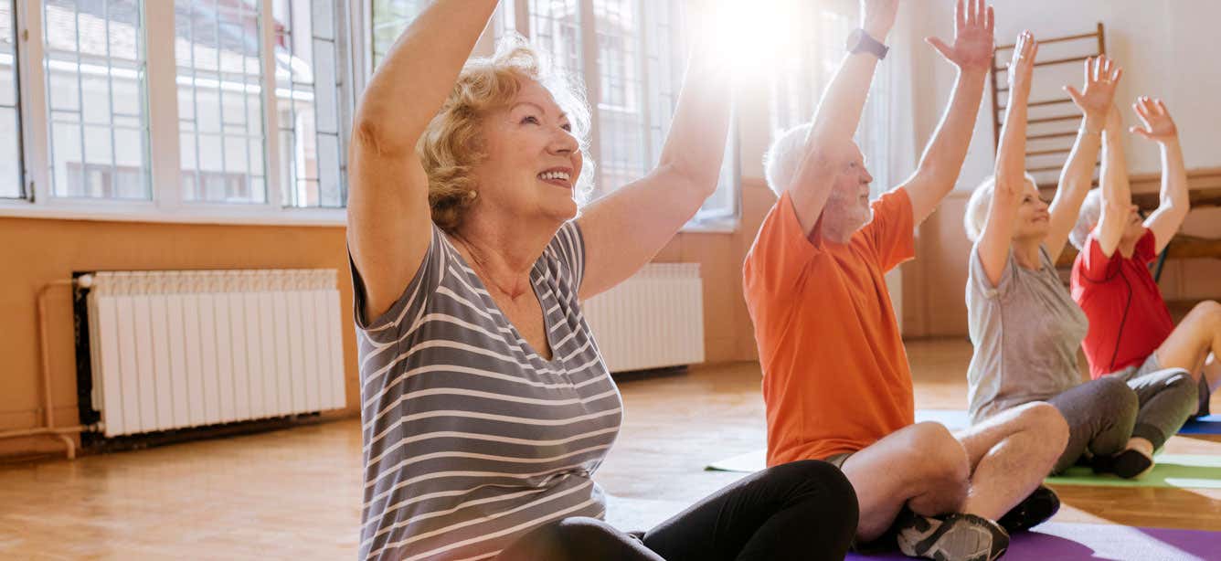 Older woman stretching with group